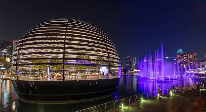 新加坡滨海湾苹果店球形玻璃建筑与紫色喷泉夜间步道